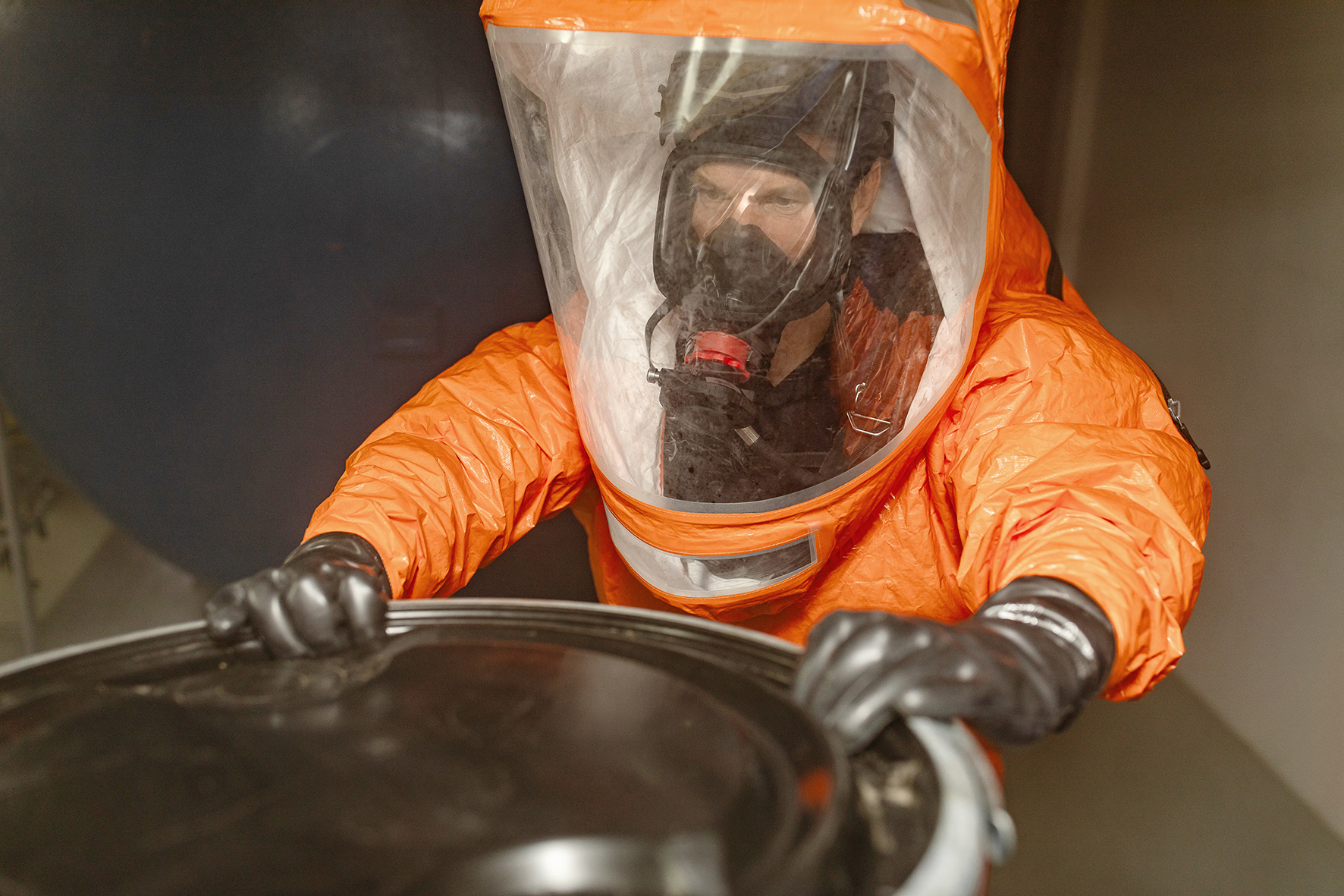 Anwendungsbild Überdruck-Vollmaske, Arbeiter in orangenem Schutzanzug von vorne